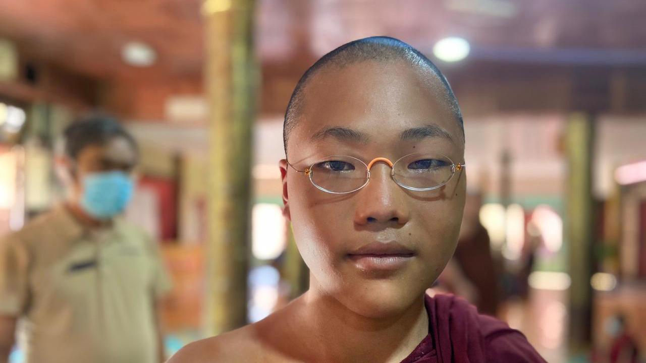 junger buddhistischer Mönch mit EinDollarBrille