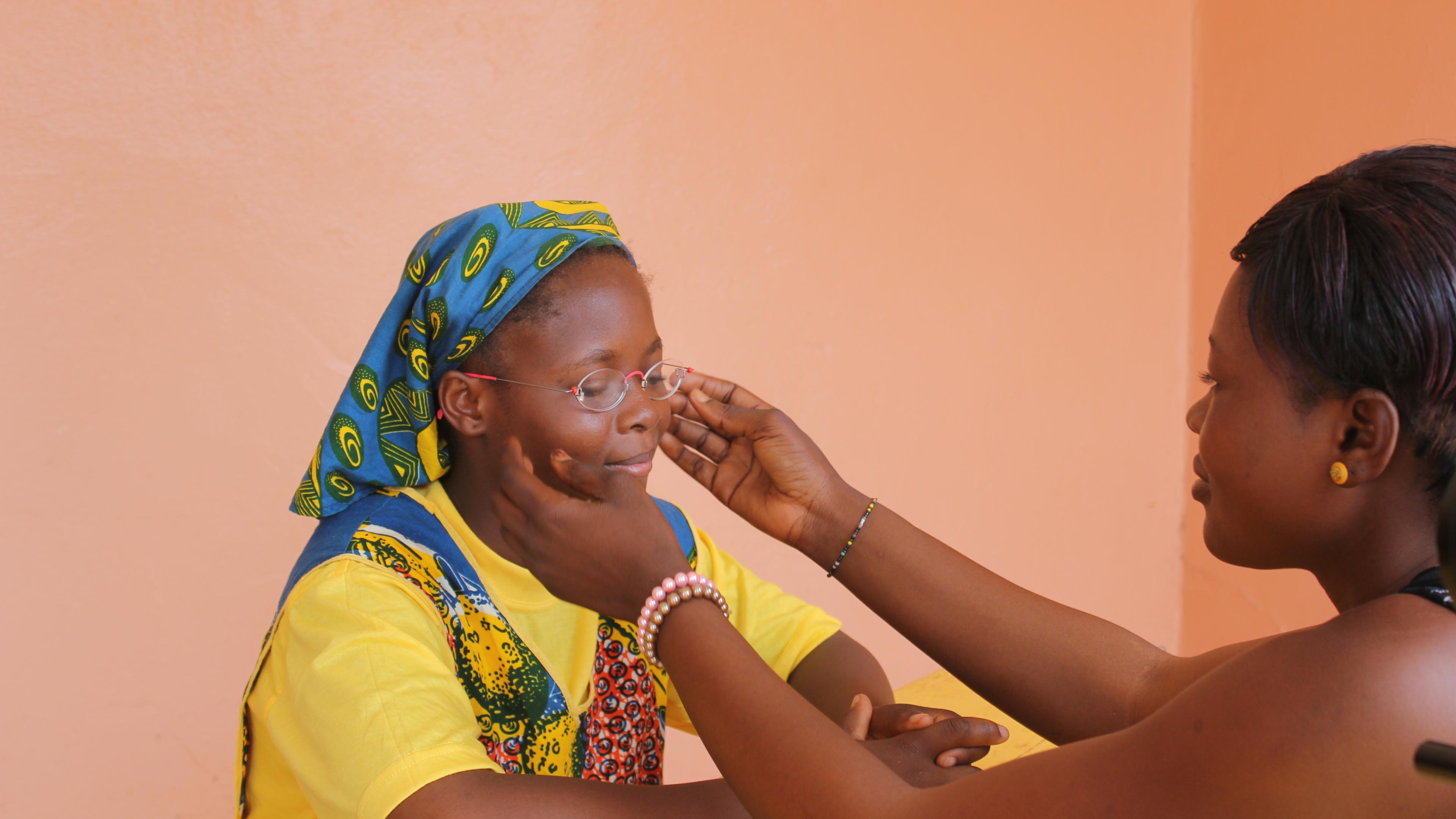 Mitarbeiterin von GoodVision Burkina Faso passt die EinDollarBrille final an