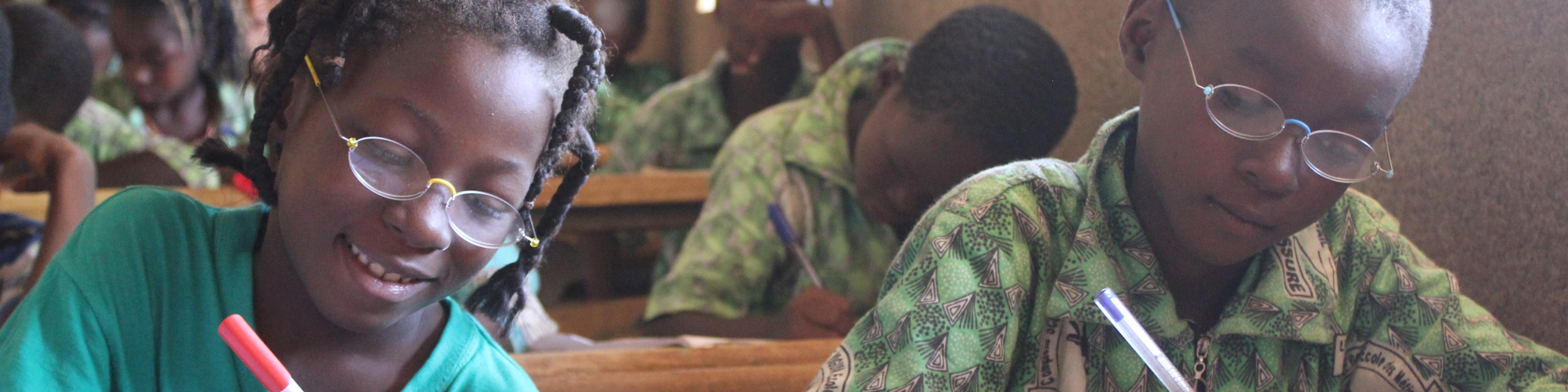 Pupils with OneDollarGlasses writing in the classroom