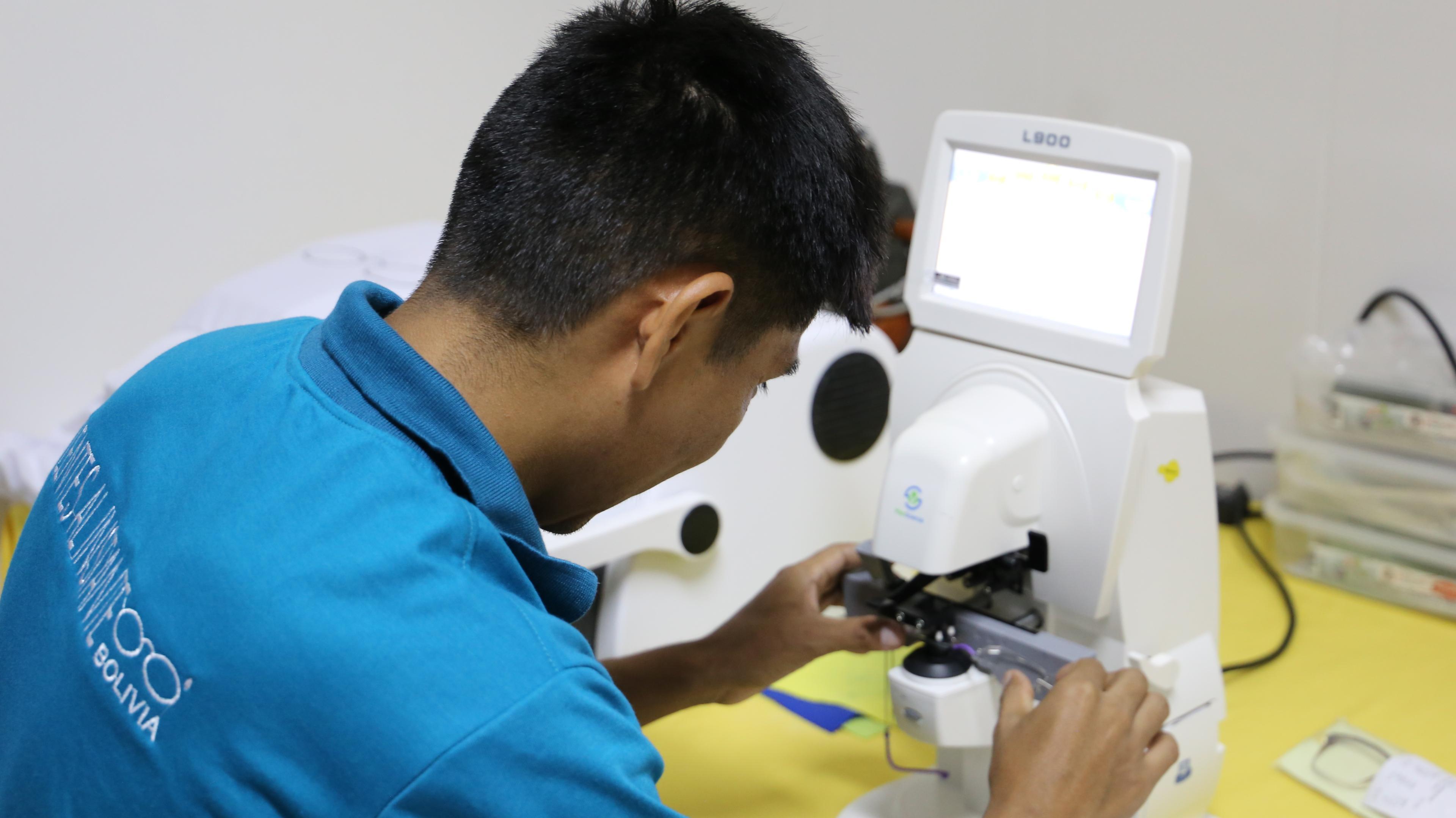 Man from Bolivia operates astigmatism grinding machine