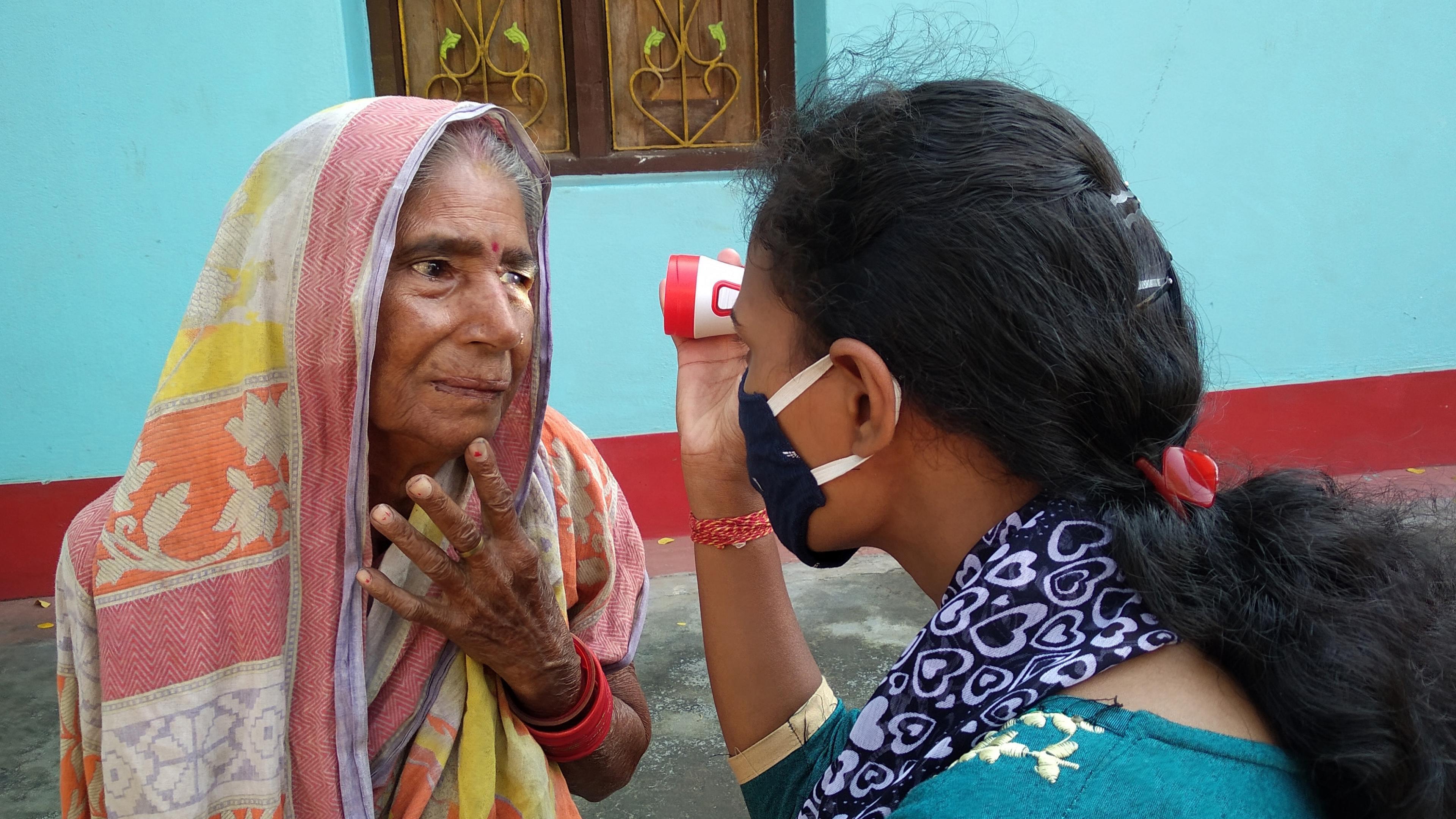 Indian woman gets an eye exam with a flashlight