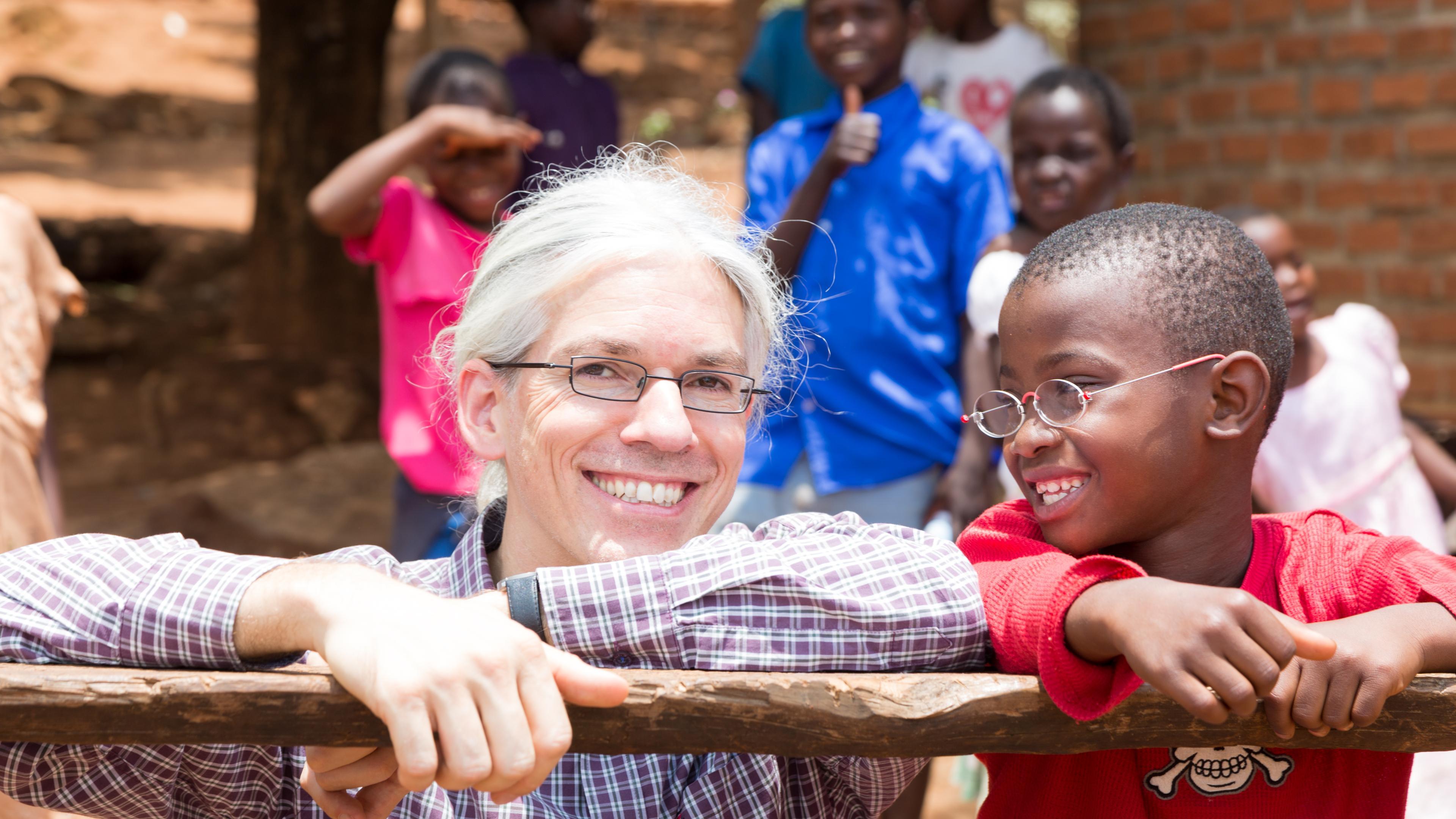 Martin Aufmuth with a boy wearing OneDollarGlasses in Malawi