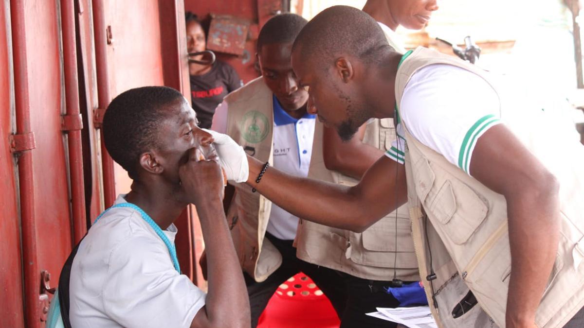 Mitarbeiter von GoodVision Liberia überprüft Auge eines Patienten