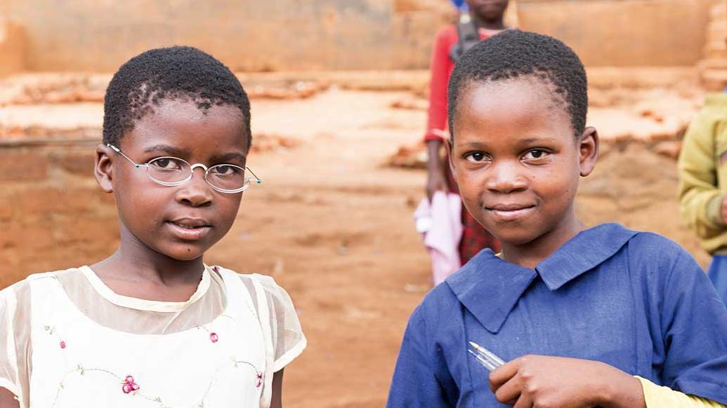 Two girls from Malawi hold hands