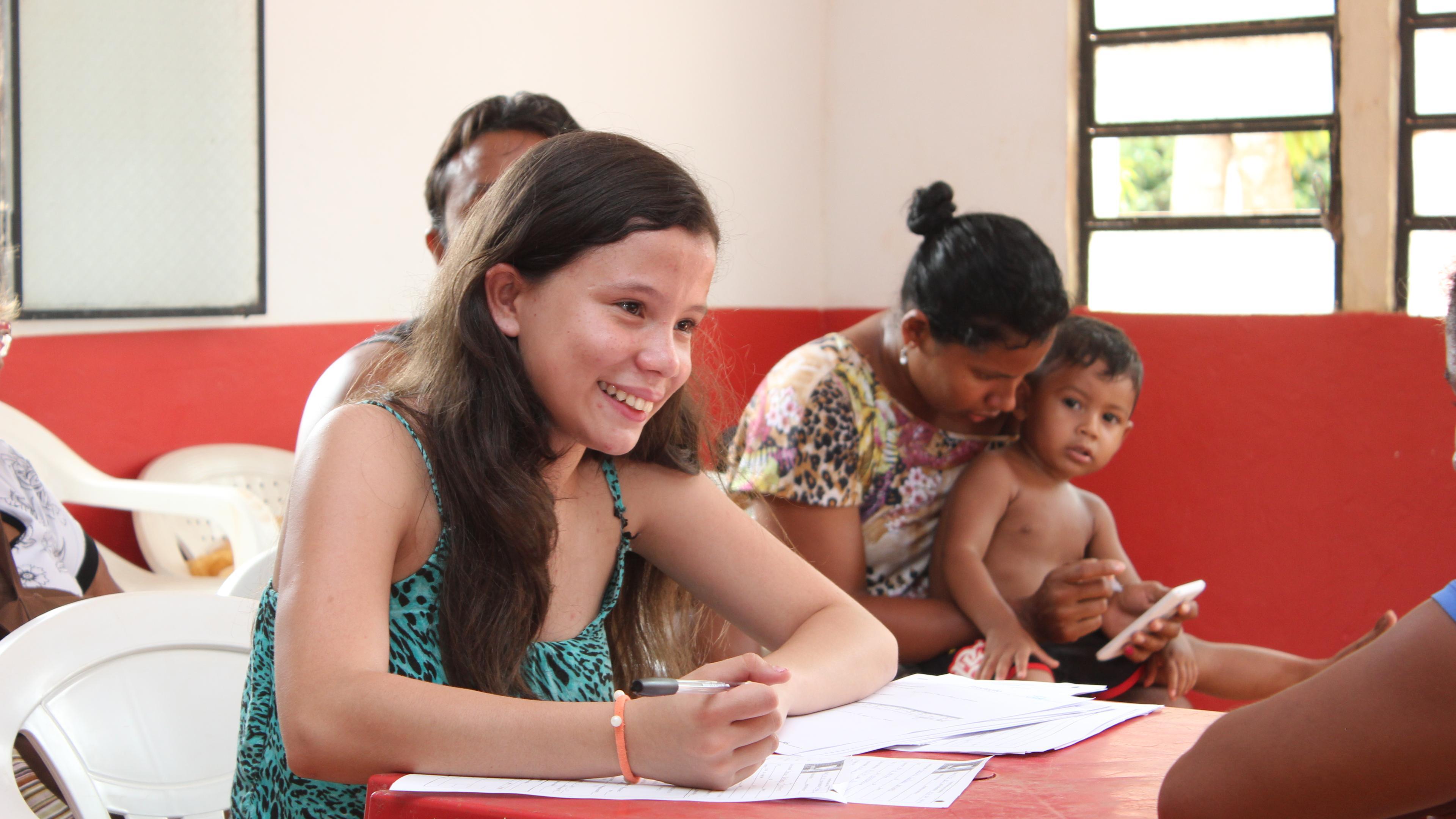 Junge Schülerin aus Brasilien beim Ausfüllen eines Dokuments