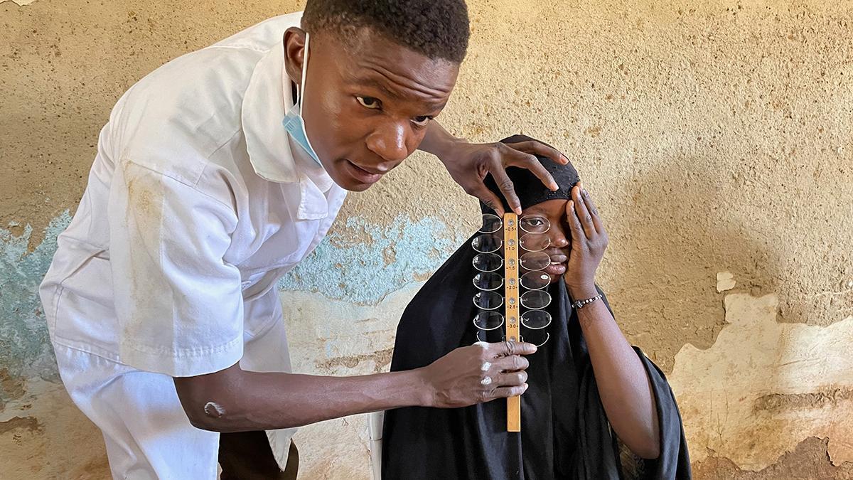 A patient in Burkina Faso receives an eye test with the alignment bar
