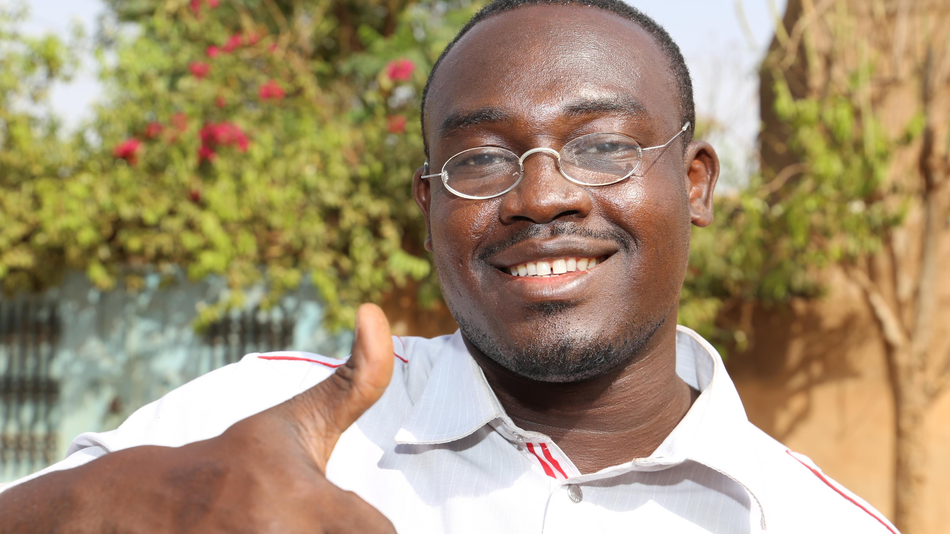 Man from Burkina Faso, wearing OneDollarGlasses, holding his thumbs up