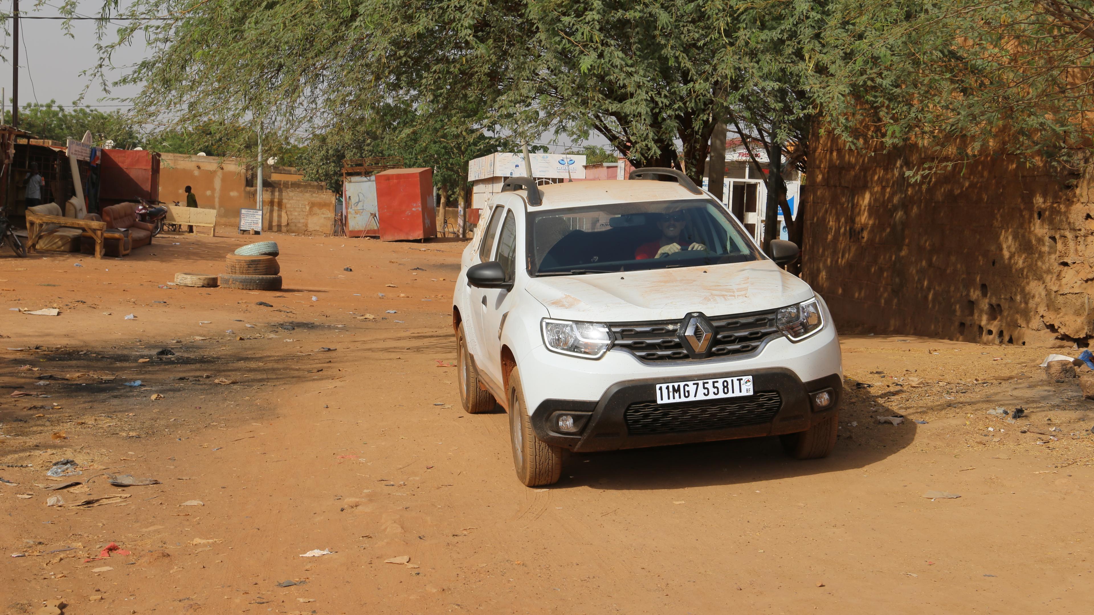Weißer Jeep in erdiger Straße in Burkina Faso