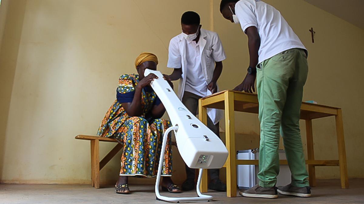 Two GoodVision Burkina Faso employees perform autorefraction on a patient using the Kaleidos autorefractometer
