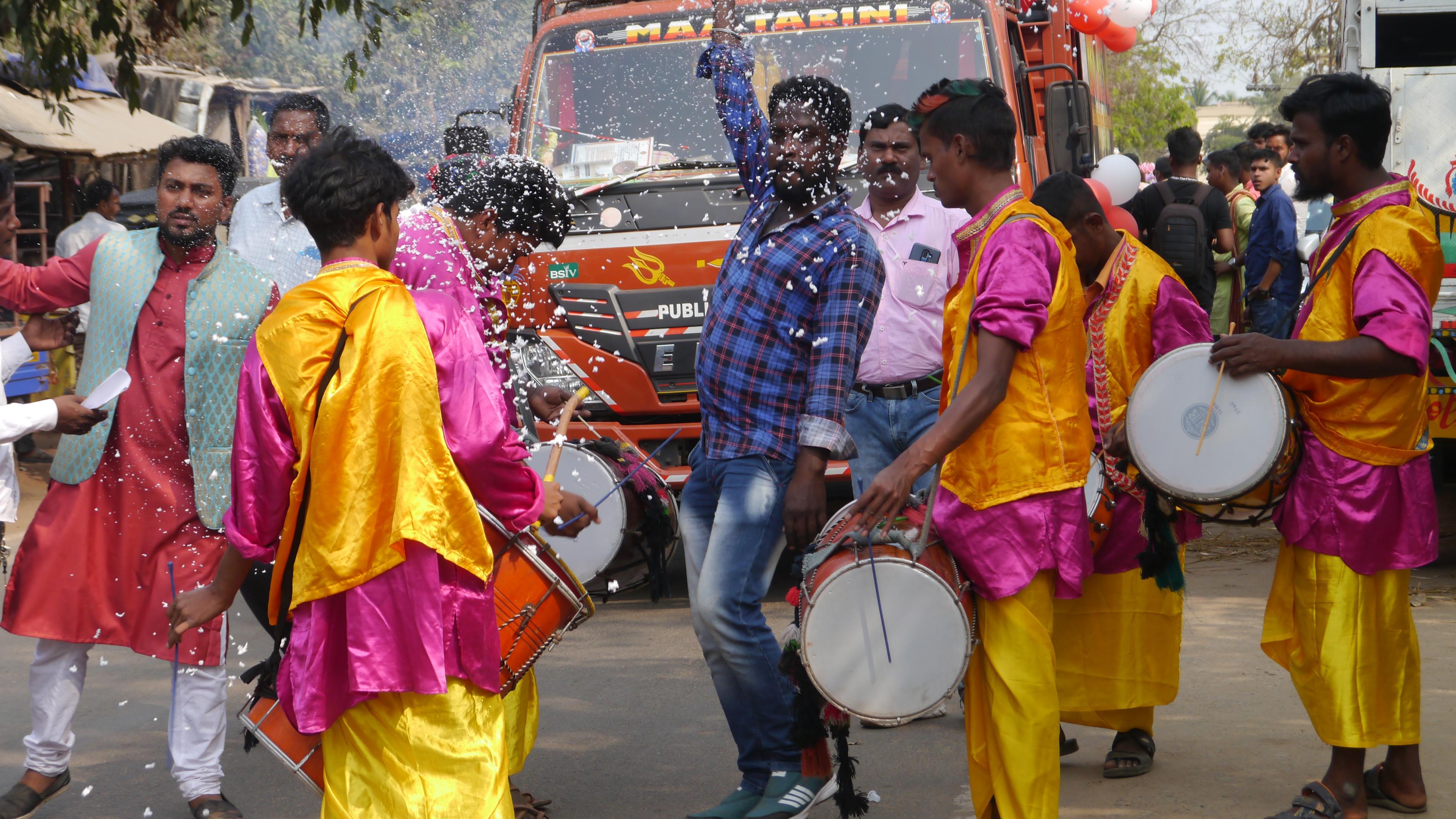 People celebrate, in costumes, with instruments, on India's streets