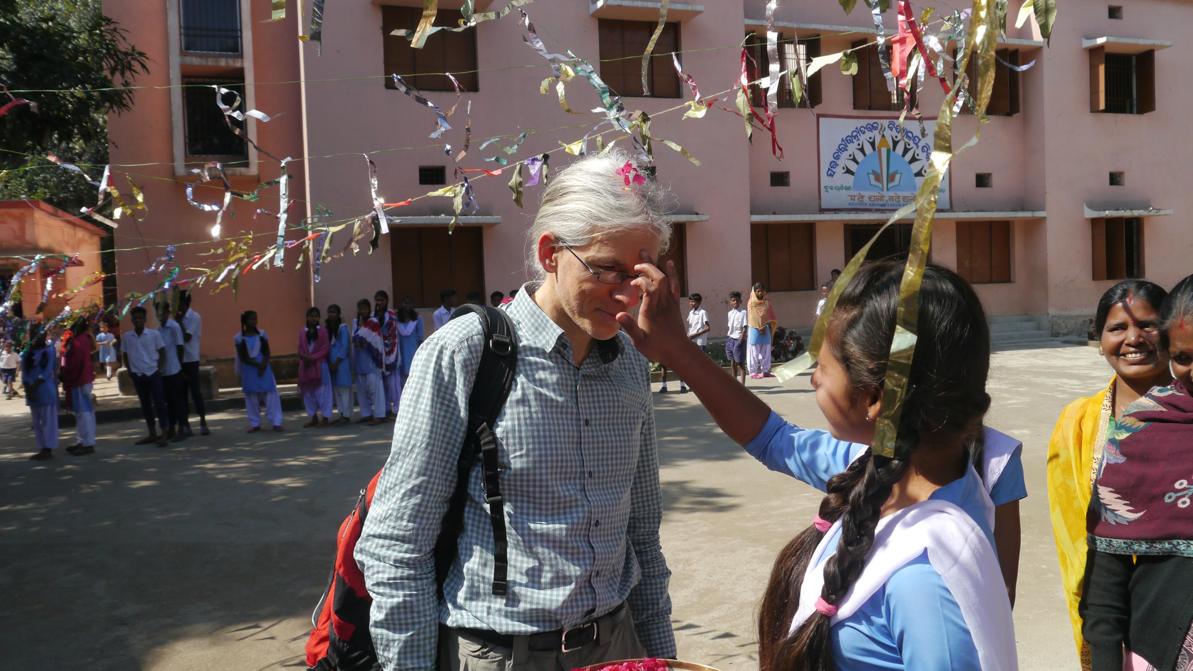 Martin Aufmuth gets his forehead painted by Indian woman