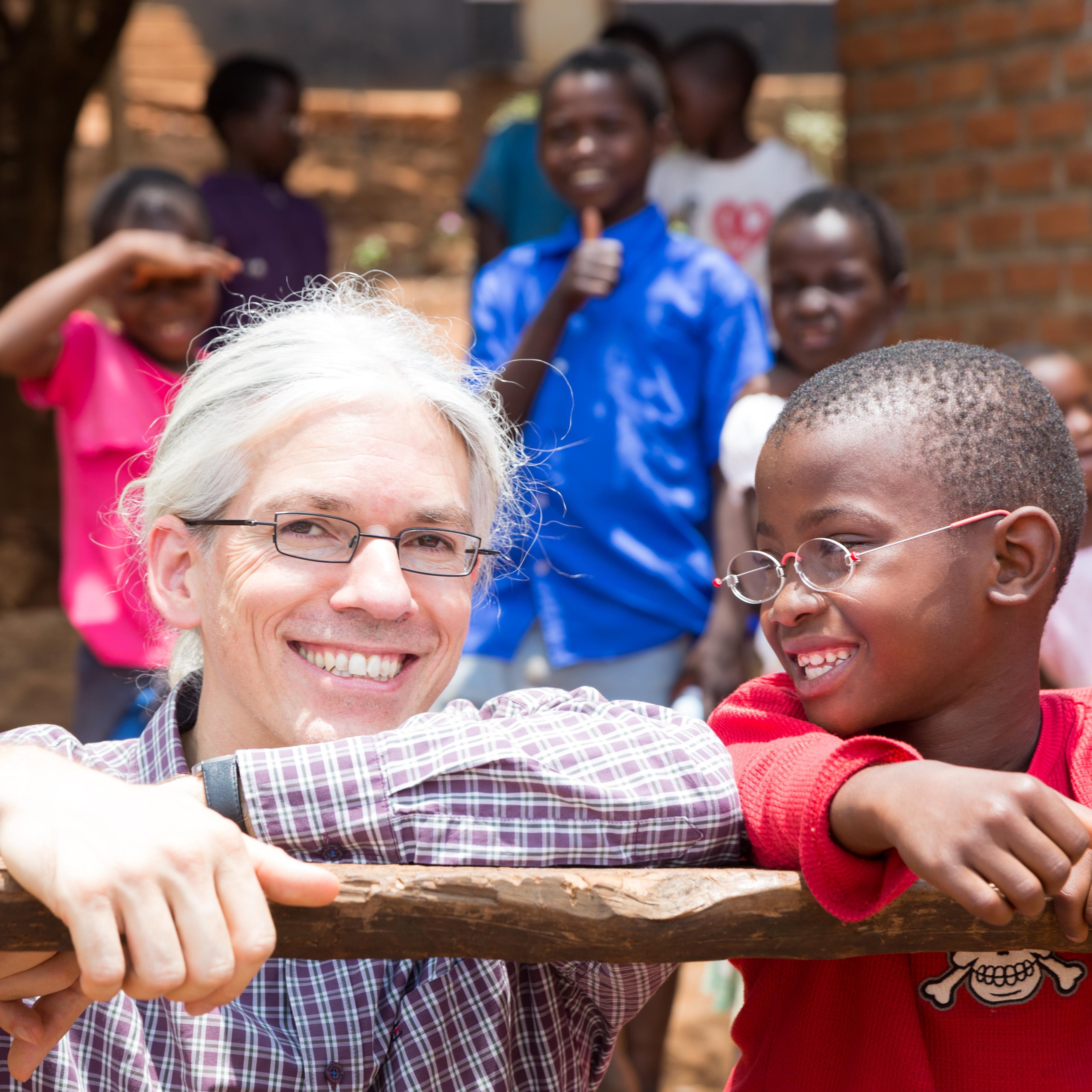 Martin Aufmuth mit einem Jungen, der EinDollarBrille trägt in Malawi