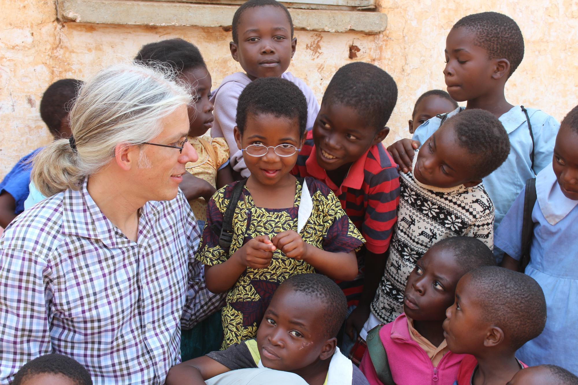 Martin Aufmuth inmitten mehrerer Kinder in Malawi