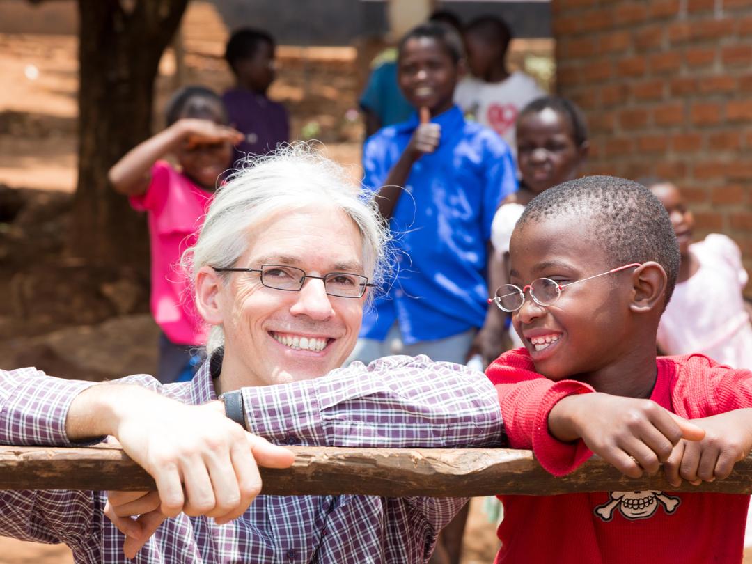 Martin Aufmuth mit einem Jungen, der EinDollarBrille trägt in Malawi