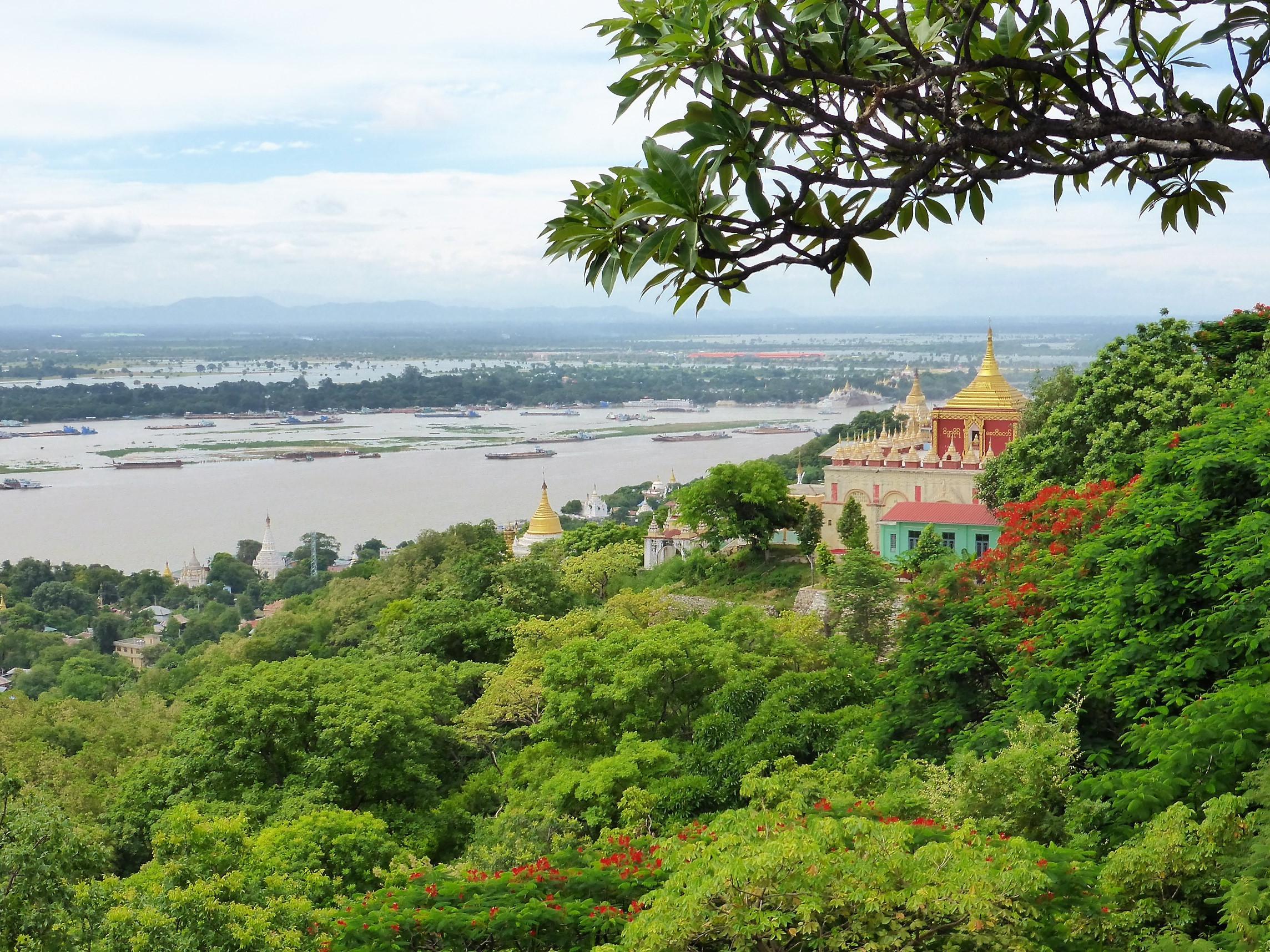 Panorama in Myanmar, grüne Wälder, Tempel mit goldenen Dächern, Fluss im Hintergrund